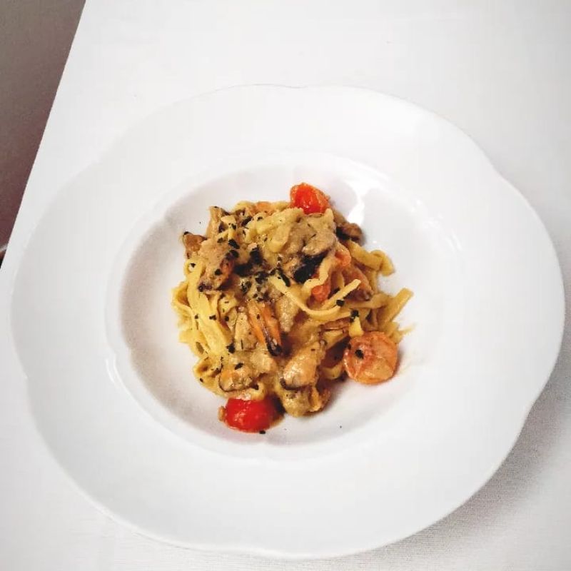 Tagliatelle mit geschaelten Muscheln Tomaten und Aubergin creme